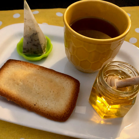 Financier with cup of tea and honey pot