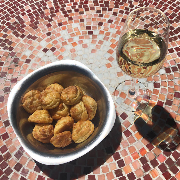 Gougères plate next to a glass of Chardonnay